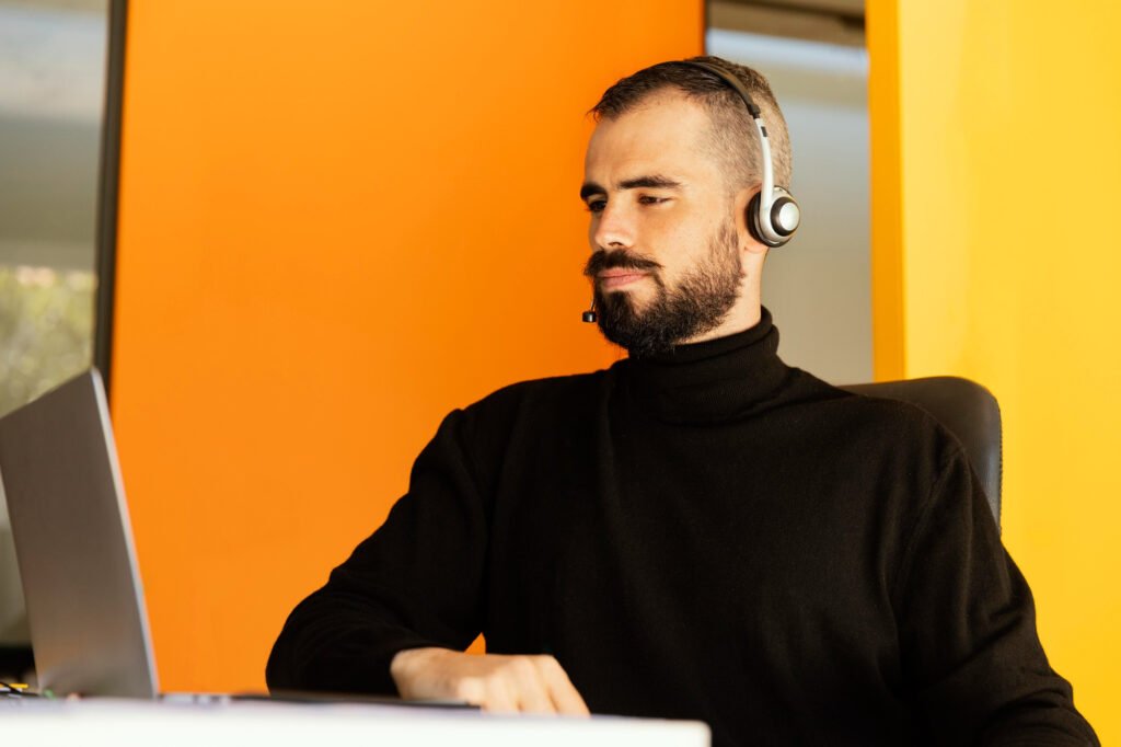 Un señor de atención al cliente atendiendo en una habitación naranja.