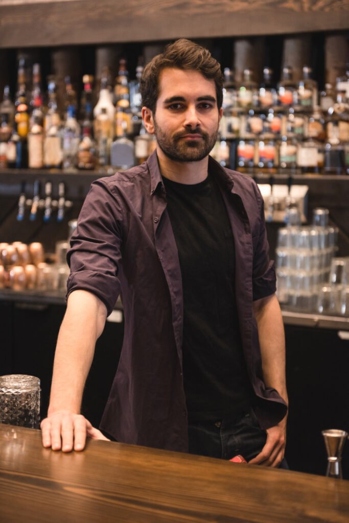 Un bartender con mano en la mesa en el lugar de trabajo.